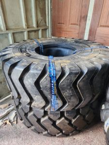 23.5-25 JIAN 18PR heavy-duty OTR tyre with deep tread lugs, manufactured in China.